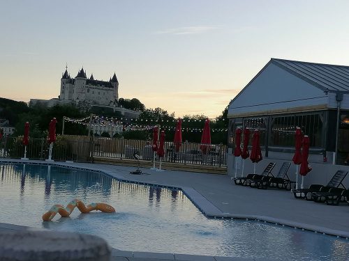 Piscina y restaurante con castillo al fondo