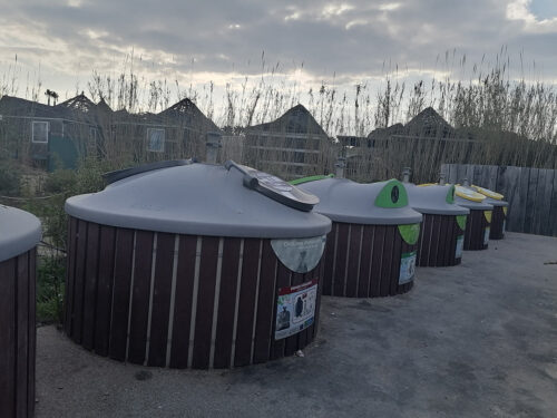 Cubos de basura en el aparcamiento de enfrente